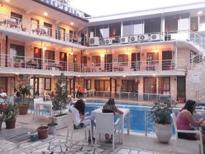 帕莫卡莱Alida Hotel的一群人坐在酒店游泳池周围
