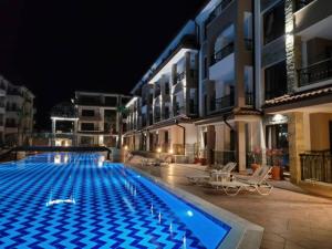 布尔加斯Bayview B32 - Burgas Beach Resort的一座游泳池,在晚上在建筑物前