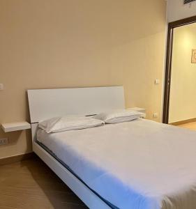 阿斯蒂ComeCasa modern apartment in historical centre的客房内的一张带两个枕头的白色床