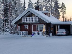 罗瓦涅米Villa Bear's的雪中停放汽车的房子