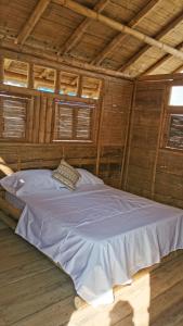La VictoriaPachingo Tatacoa Desert的配有木制天花板的客房内一张白色大床