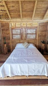 La VictoriaPachingo Tatacoa Desert的木间设有一张大床,设有两个窗户