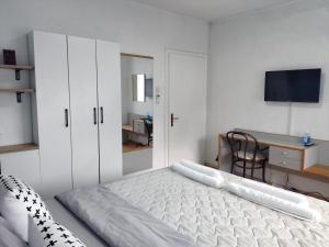 奥赫里德豪斯公寓及客房的白色卧室配有床和书桌