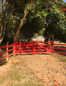 康赛瓦托利亚Vivenda dos Guaranys: casa + loft的树木繁茂的田野前的红栅栏