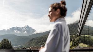 索尔登索尔登贝格生活酒店的窗外的山峰上的一个女人