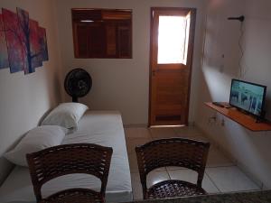 São Gonçalo do AmaranteCasa do Mochileiro Airport Hostel的一间卧室配有一张床、两把椅子和一个窗户
