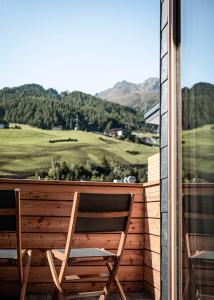 索尔登索尔登贝格生活酒店的坐在房子阳台上的木椅