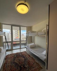 伯利恒Bethlehem City Hostel的客房设有两张双层床和大窗户。