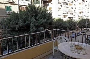 开罗Jessy Charming apartment in Heliopolis的一个带桌椅的阳台和一座建筑