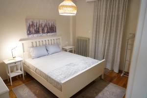 拉里萨Larissa Downtown Apartment With Parking的卧室配有白色的床和吊灯。