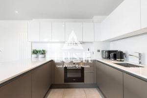 伦敦Modern, Stylish PENTHOUSE Apartment next to Wembley Stadium!的厨房配有白色橱柜和炉灶烤箱。