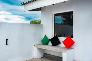 贾埃勒Eden Studio Apartments - 2的两块五颜六色的枕头坐在房子的长凳上