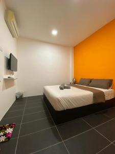 务边YipStay的一间卧室配有一张橙色墙壁的床