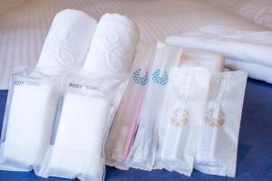 京都Stay SAKURA Kyoto Shijo Karasuma的一组白色毛巾坐在床边