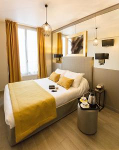 巴黎普拉蒂克酒店的一间卧室配有一张带黄色毯子的大床