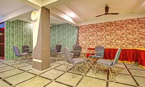 海得拉巴Itsy Hotels Sunrise Grand的一间设有椅子和桌子的房间和砖墙