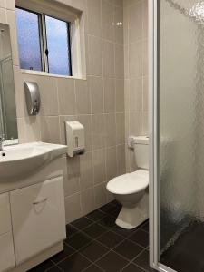 奥古斯塔港奥古斯塔庭院汽车旅馆的浴室配有卫生间、盥洗盆和淋浴。