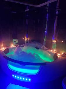 弗吕埃伦San Marco Vip的客房内的热水浴池配有蓝色和绿色的灯光