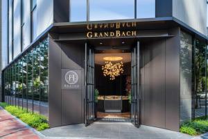 东京Hotel GrandBach Tokyo Ginza的通往带吊灯的宏伟黑色建筑的门道