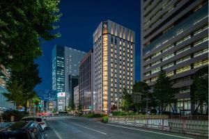 东京Hotel GrandBach Tokyo Ginza的夜幕降临的城市街道上一座高楼