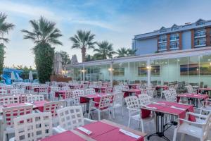 凯麦尔Armas Beach的餐厅设有红色和白色的桌椅