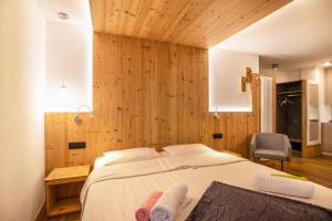坎皮泰洛迪法萨Chalet Osmar Suite 2的一间卧室配有一张带木墙的大床