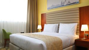 阿布扎比Al Riyadh Hotel Apartments的一间设有大床和窗户的酒店客房