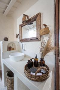 龙目岛库塔Drop In Surf Lodge的浴室设有水槽和镜子,位于柜台上