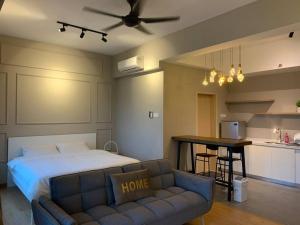 关丹Kuantan Seaview Studio@Imperium Residence TgLumpur的一间卧室配有一张床和一张沙发,还设有一间厨房