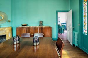 昂热La Maison de Florence的一间设有木桌和蓝色墙壁的用餐室