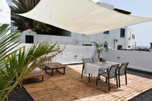 埃尔戈尔福Sabbia Suite Casa Jalofa的庭院配有桌椅和白色遮阳伞。