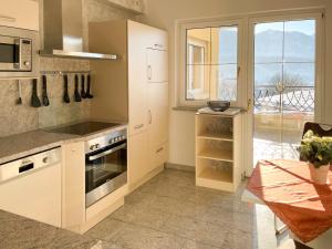 黑马戈尔维多利亚别墅公寓的厨房配有白色橱柜、桌子和窗户。