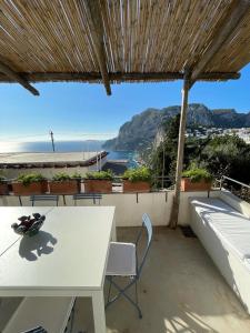 卡普里Le Rocce da Tragara, Tragara essential的海景阳台上的桌椅