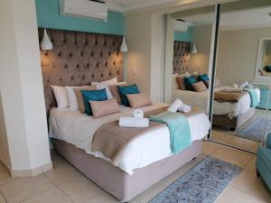 德班307 Bermudas - by Stay in Umhlanga的一间卧室设有两张床和大镜子