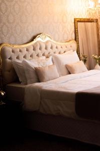 里约热内卢波萨达瓜纳巴拉花园酒店的白色的床,配有金色的框架和白色的枕头