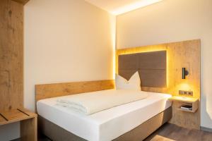哈尔伯格摩斯Hotel Neuwirt的卧室配有白色的床和木制床头板