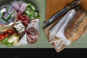 赞丹De oude slaght- luxe suite met buitensauna的托盘,包括面包、奶酪和蔬菜
