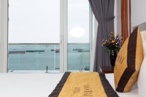 头顿Sao Mai Hotel & Apartment的一间卧室设有一张床,享有海景