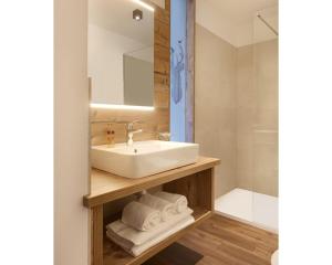 泰塞罗Hotel Al Cervo的一间带水槽、镜子和淋浴的浴室