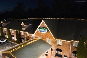弗拉特罗克Mountain Inn & Suites Flat Rock的建筑的侧面有圣诞灯