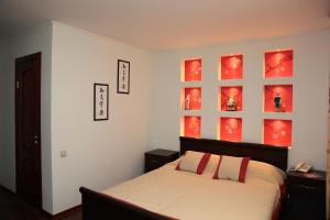 克麦罗沃Hotel Evraziya的卧室配有一张挂在墙上的红色镶板床。