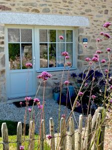 普卢贡韦兰La Grange Neuve的蓝色门和粉红色花的房子