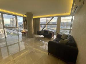 伯萨Le Luxe Suites Hotel & Spa的带沙发和大窗户的客厅
