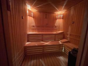 伯萨Le Luxe Suites Hotel & Spa的一间设有木镶板和灯光的桑拿浴室