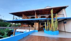 巴克里索莫雷诺港Galápagos Casa Playa Mann的一座拥有蓝色屋顶的建筑,上面有很多冲浪板