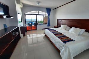巴克里索莫雷诺港Galápagos Casa Playa Mann的一间卧室配有一张大床和电视
