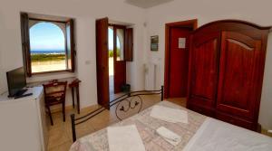 奥斯图尼La Piana degli Ulivi的一间卧室配有一张床、一张书桌和一个窗户。