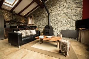 恩坎普R de Rural - Casa Rural de les Arnes的客厅设有真皮沙发和石墙