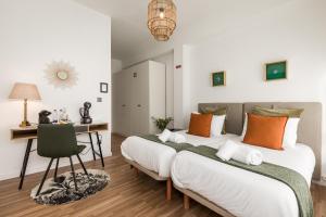 波尔图Porto Essence的配有两张床铺的客房配有一张桌子和一把椅子