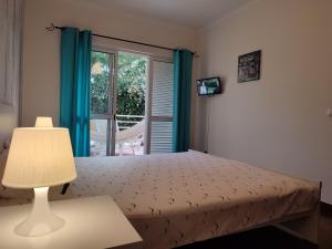 卡尼索Refugio Madeira的一间卧室配有一张带蓝色窗帘的床和一扇窗户